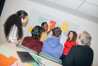 Colleagues collaborate around a table during a presentation.